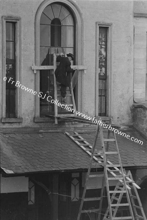 MAN FITTING LEADED GLASS TO RERE OF 35 LEESON STREET